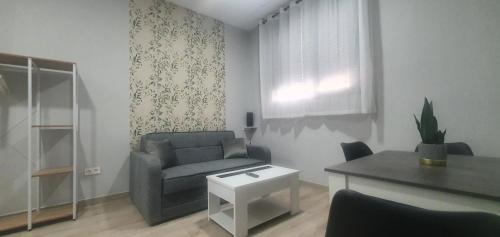 a living room with a couch and a table at Apartamentos Las trece llaves Jacuzzi bajo reserva in Merida