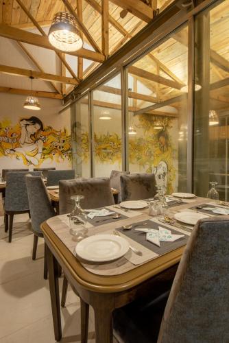 a dining room with a large wooden table and chairs at Cecil by Pearl Continental in Murree