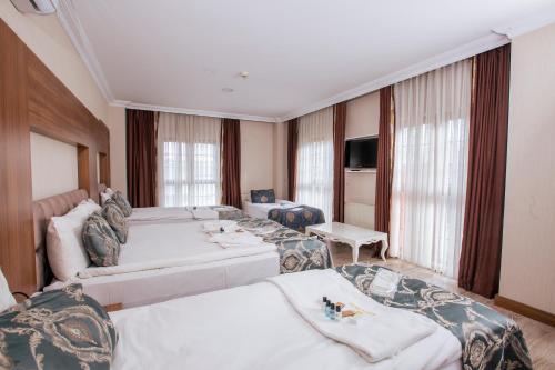 a hotel room with two beds and a television at Bursa Palas Hotel in Bursa