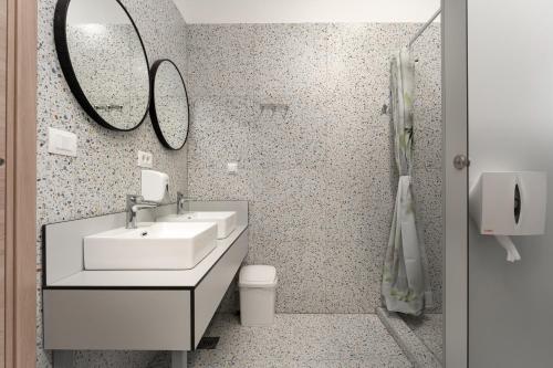 a bathroom with a sink and a toilet and a mirror at Hostel Antique in Pula