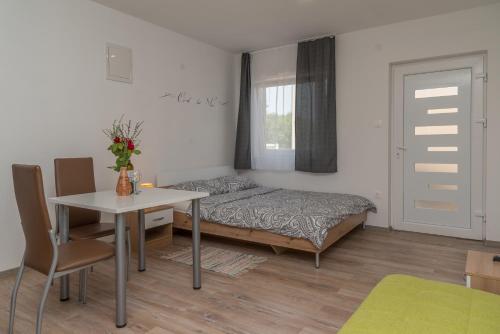 a bedroom with a bed and a table and a desk at Apartmani Kržak in Nin