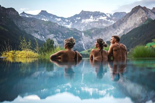 a group of people standing in the water in the mountains at The Cambrian in Adelboden