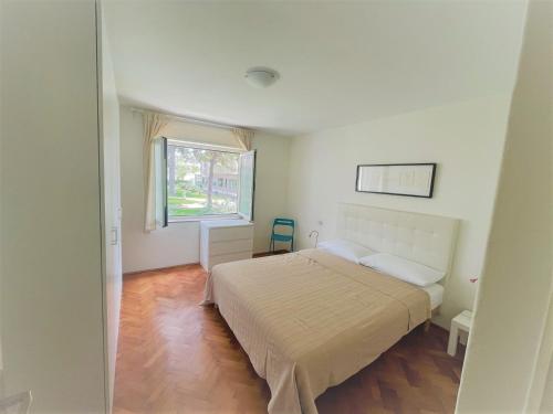 een slaapkamer met een groot bed en een raam bij Faber Apartments in Novigrad Istria