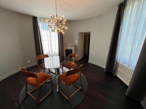 a dining room with a table and chairs and a chandelier at Le Petit Château in Baye