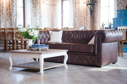 a brown leather couch in a living room with a coffee table at Penzion Na Bělisku in Březiny