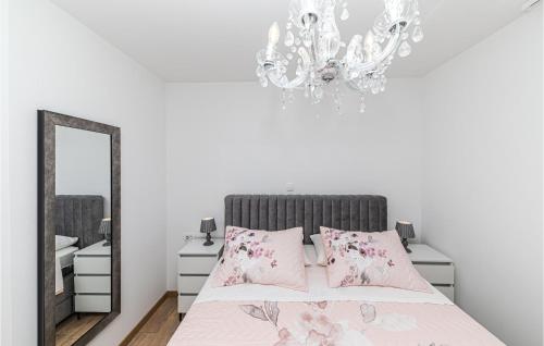 - une chambre avec un lit, un lustre et un miroir dans l'établissement Awesome Apartment In Seget Donji With Wifi, à Donji Seget