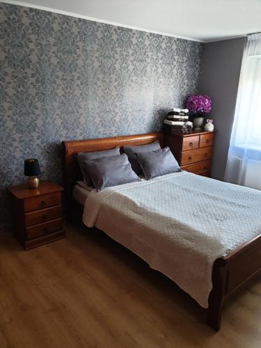 a bedroom with a bed and two dressers and a window at Pie jūras in Liepāja