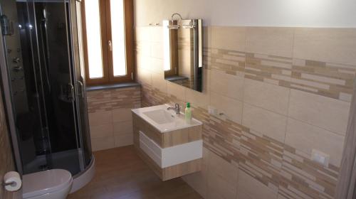 ein Bad mit einem Waschbecken, einer Dusche und einem WC in der Unterkunft Perdanoa in Ghilarza