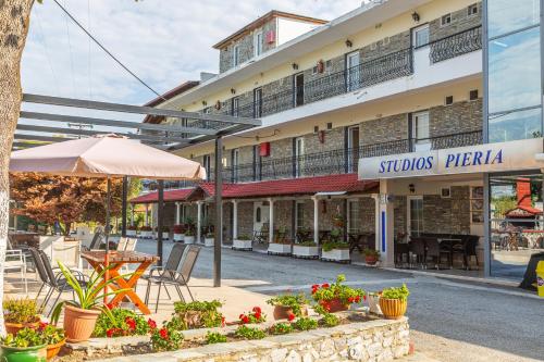 a building on a street with a table and chairs at Sun Studios Pieria in Paralía Skotínis