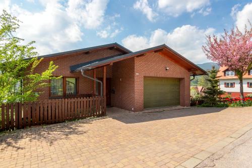 a brick house with a garage on a brick driveway at Vila Sluneční stráň in Svoboda nad Úpou