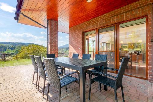 a dining room table and chairs on a patio at Vila Sluneční stráň in Svoboda nad Úpou