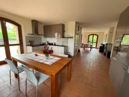 a kitchen and dining room with a wooden table and chairs at Agriturismo Podere Prasiano in Marano sul Panaro