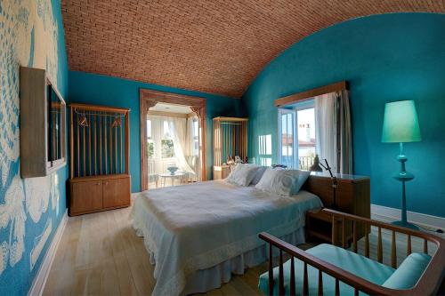 a blue bedroom with a bed and a chair at On Oda Alaçatı in Alaçatı