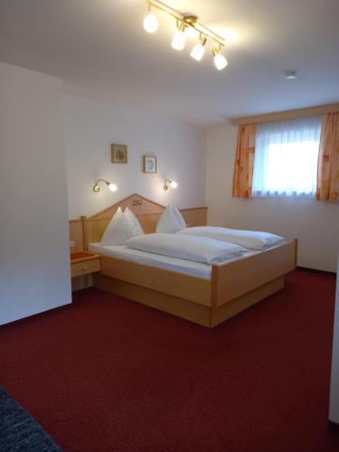 a bedroom with a large bed in a room with red carpet at Landhaus Wieser in Ramsau am Dachstein