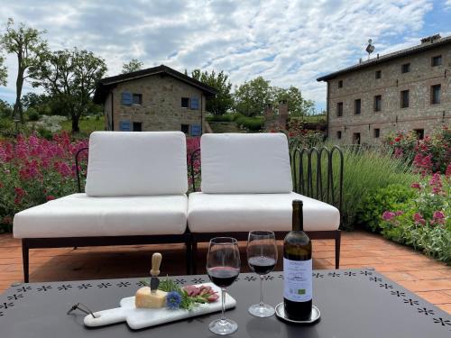 a bottle of wine and two glasses on a table at Agriturismo Podere Prasiano in Marano sul Panaro