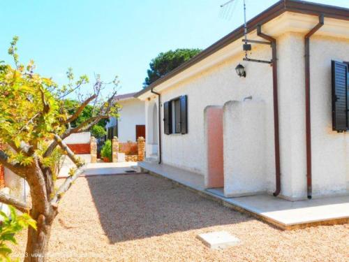 uma casa branca com uma árvore em frente em Bilo Lu Rattali em San Teodoro