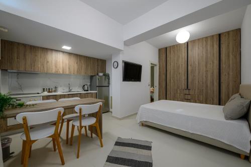 1 dormitorio con 1 cama, mesa y sillas en Little cozy room by the sea en Messini