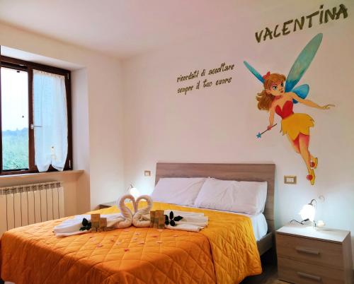 a bedroom with a bed with a fairy on the wall at IL VILLAGGIO DELLE FATE in Macerata