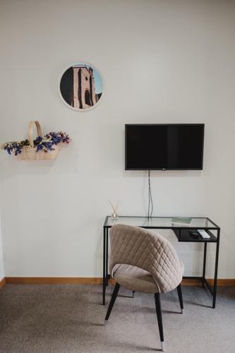 a room with a desk and a chair and a television at Alojamento 88 in Castro Daire