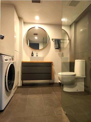 a bathroom with a toilet and a sink and a mirror at Villas Sienna Homestay in Gold Coast