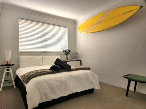 a bedroom with a surfboard hanging on the wall at Villas Sienna Homestay in Gold Coast