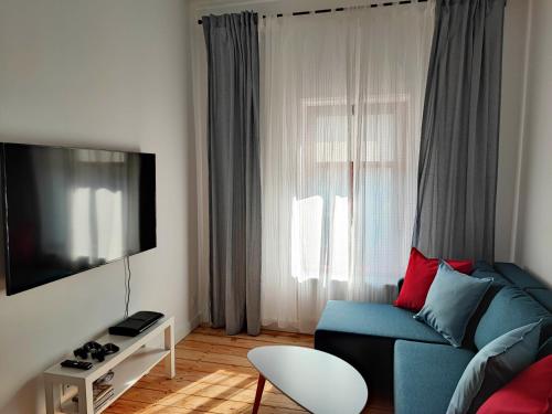 a living room with a blue couch and a window at Centrum Apartament Przytulny in Świdnica