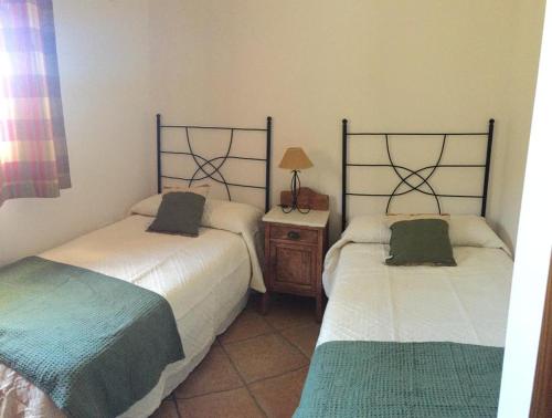 Zimmer mit 2 Betten und einem Tisch mit einer Lampe in der Unterkunft Al-Medin in Trevélez