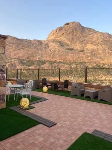 a patio with a table and chairs and a mountain at أزد للشقق المخدومة in Tanomah