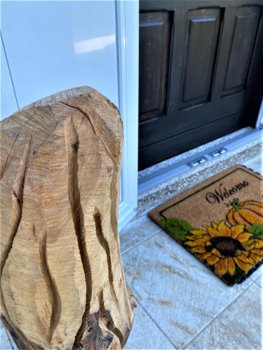 a wooden stump sitting in front of a door at Kuća Homer in Mala Lešnica