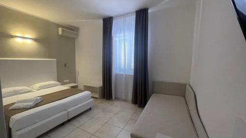 a small bedroom with a bed and a window at Hotel L'Ogliera in Pomonte
