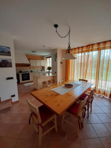 a kitchen and dining room with a wooden table and chairs at San Marcello Residence in Feltre