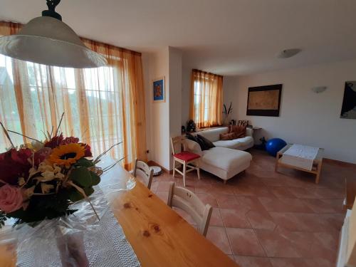 a living room with a table with a vase of flowers at San Marcello Residence in Feltre