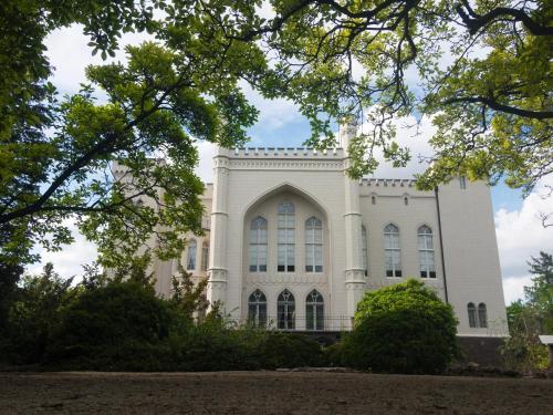 a white building with trees in front of it at NIENOVO - Apartament Kórnik niedaleko jeziora i widok na Arboretum in Kórnik