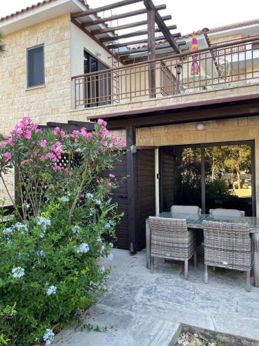 a patio with a table and chairs and a balcony at 2 Palaepaphos Gardens in Kouklia