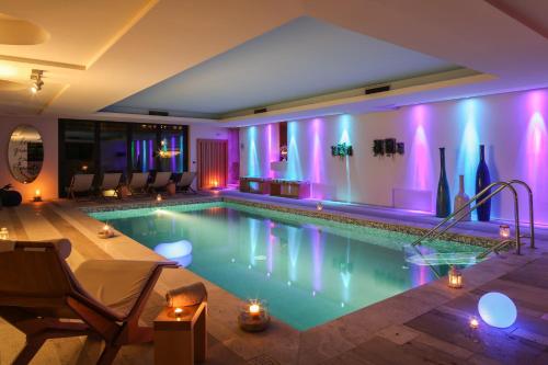 a swimming pool in a room with purple lights at Roccafiore Wine Resort & Spa in Todi