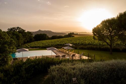 a view of a farm with the sun setting in a field at Roccafiore Wine Resort & Spa in Todi