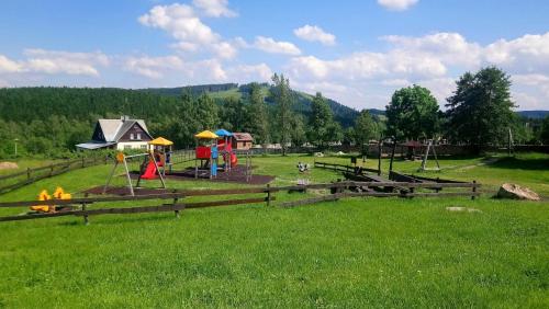 a park with a playground in a green field at Blatenský House 393 - Apartmá 3 in Abertamy