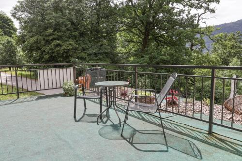 a table and chairs on a balcony with a fence at Tourist farm Mulej in Bled