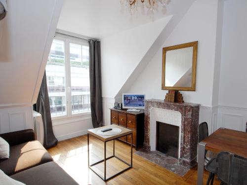 een woonkamer met een open haard en een spiegel bij Appart'Tourisme Paris Porte de Versailles in Parijs