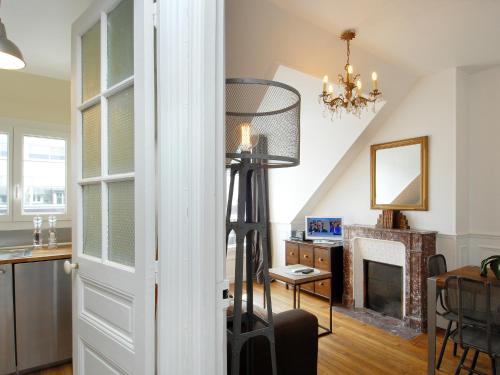 a living room with a fireplace and a chandelier at Appart'Tourisme Paris Porte de Versailles in Paris