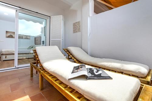 Habitación con una fila de camas con ventana en Livemálaga San Telmo Beach, en Málaga