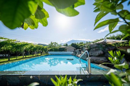 a swimming pool with a rock wall around it at Hotel Frangart an der Weinstraße in Appiano sulla Strada del Vino