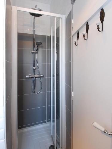 une douche avec une porte vitrée dans une salle de bain dans l'établissement Appart'Tourisme Paris Porte de Versailles, à Paris