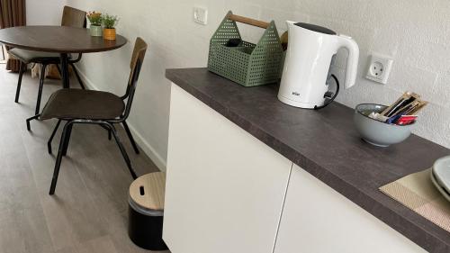 a kitchen counter with a mixer and a table at Holiday Rooms Møllebo in Ansager