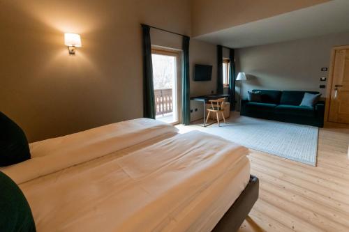 a bedroom with a large bed and a living room at Alpi & Golf Hotel in Bormio