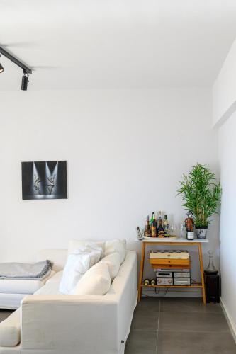 a white living room with a white couch at 5 meters from the beach in Chrani