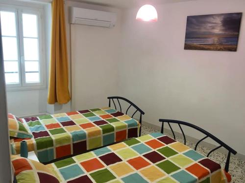dwa łóżka siedzące obok siebie w pokoju w obiekcie Agréable maison au cœur du village w Argelès-sur-Mer
