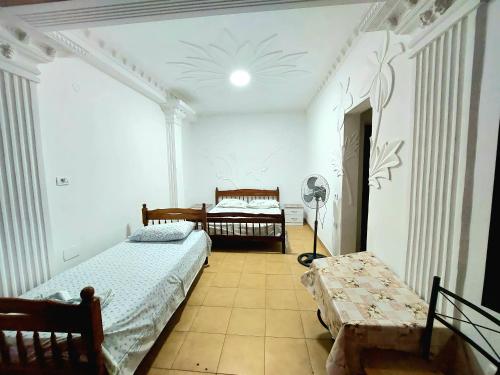 a bedroom with two beds and a table in it at Villa Kasa in Durrës