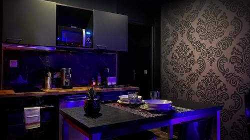 una cocina con una mesa con luz púrpura en NOUVEAU - LUXURE - Secret Suite - JACUZZI en Melun