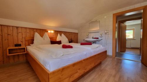 ein Schlafzimmer mit einem großen weißen Bett mit roten Kissen in der Unterkunft Sonnenkogel in Galtür